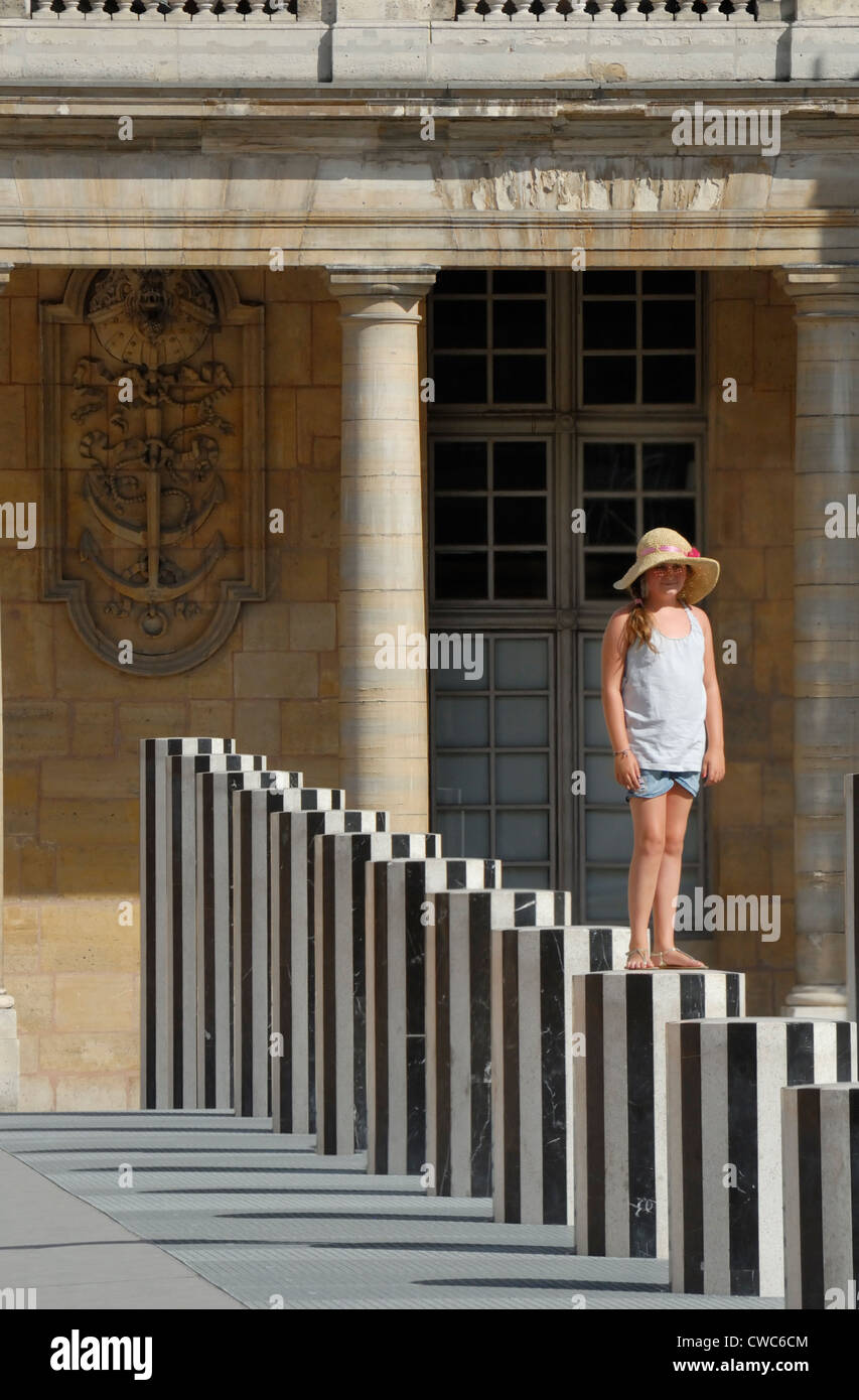 Parigi, Francia. Palais Royal. Giovane ragazza in piedi sul pilastro della Cour d'Honneur Foto Stock