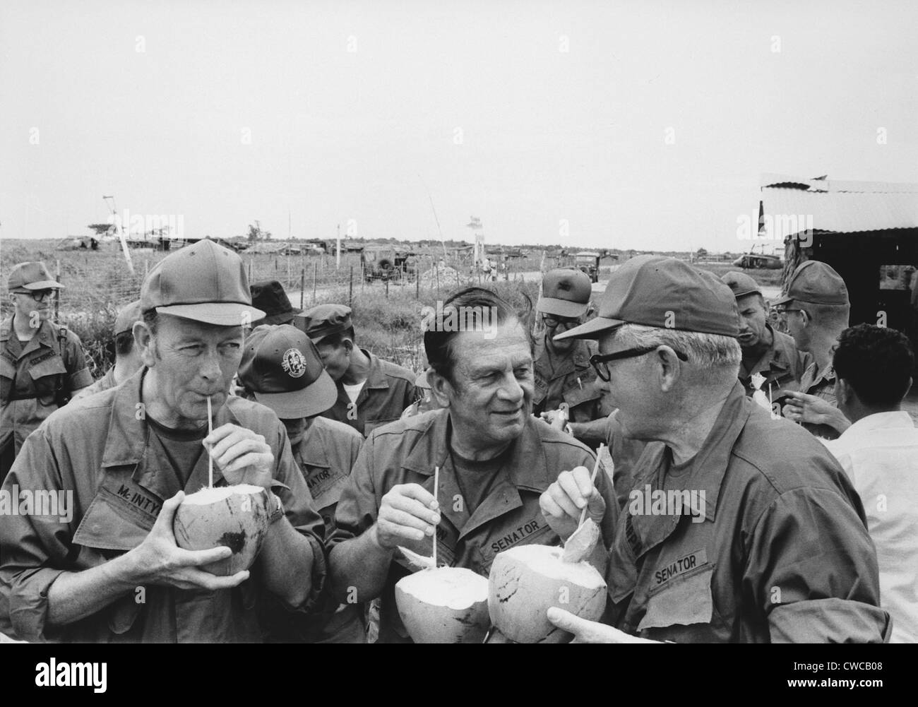 Noi senatori bere da noci di cocco su una fact finding mission hanno girato il recente "pacificato' Sud villaggio vietnamita di Huu Foto Stock