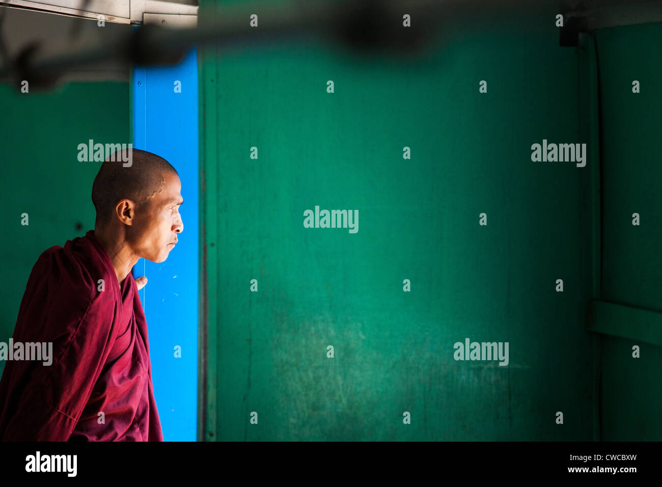 Monaco buddista in un treno a Yangon, Myanmar Foto Stock