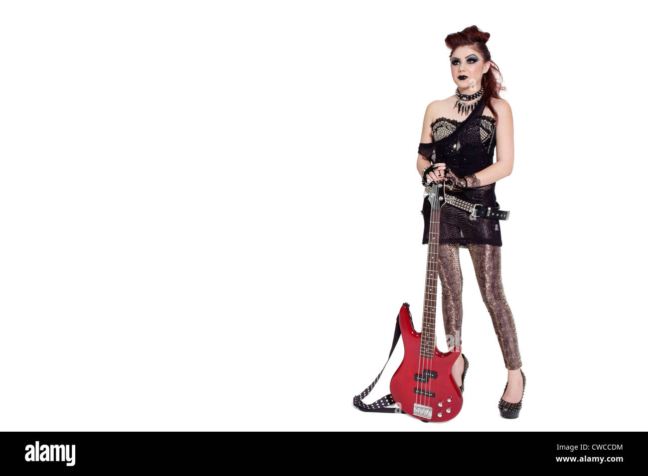 Bella giovane punk donna in piedi con la chitarra su sfondo bianco Foto Stock