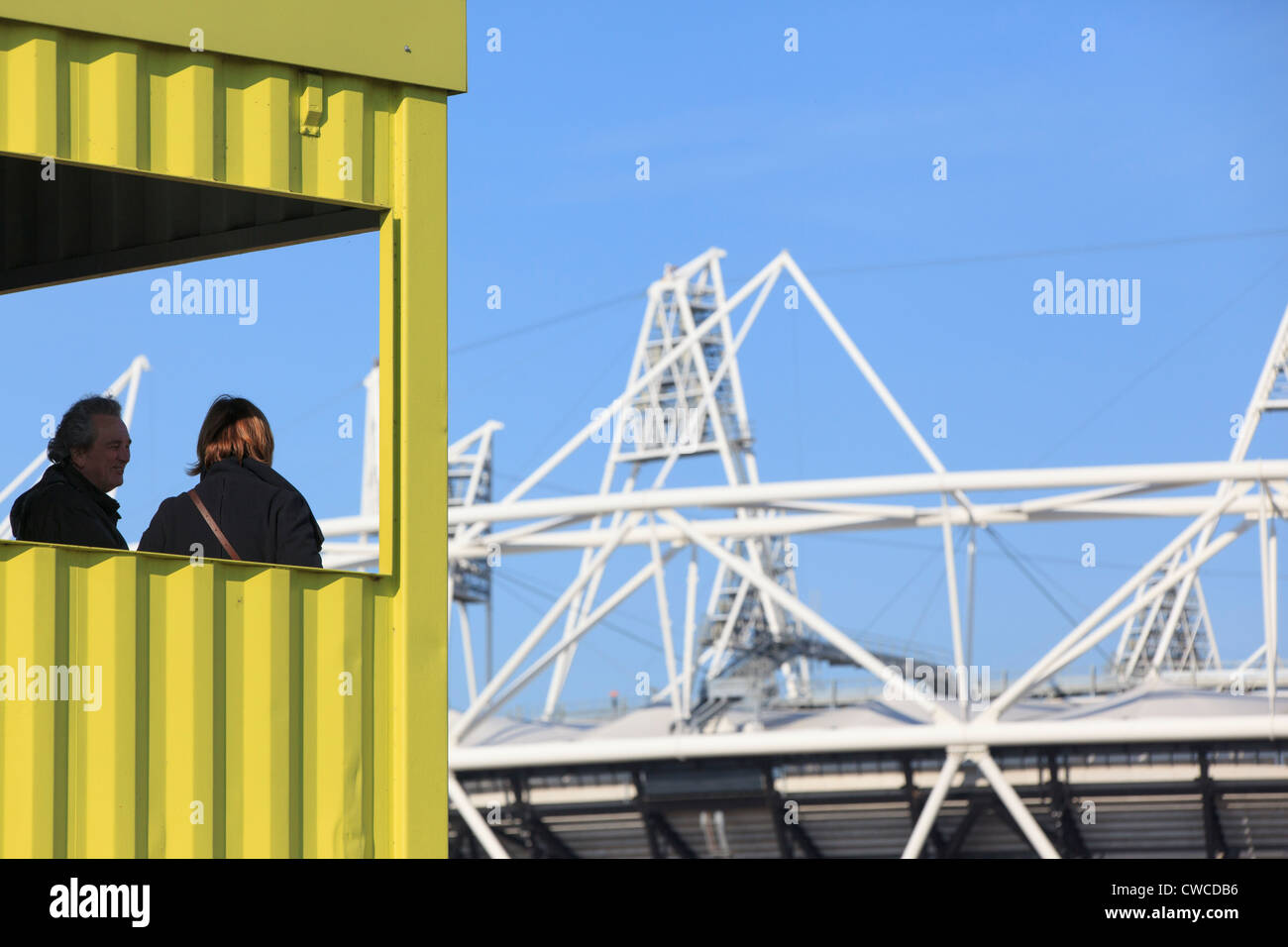 Due persone che guardano in basso verso lo stadio olimpico dal tubo di visualizzazione su Greenway nella zona est di Londra Foto Stock