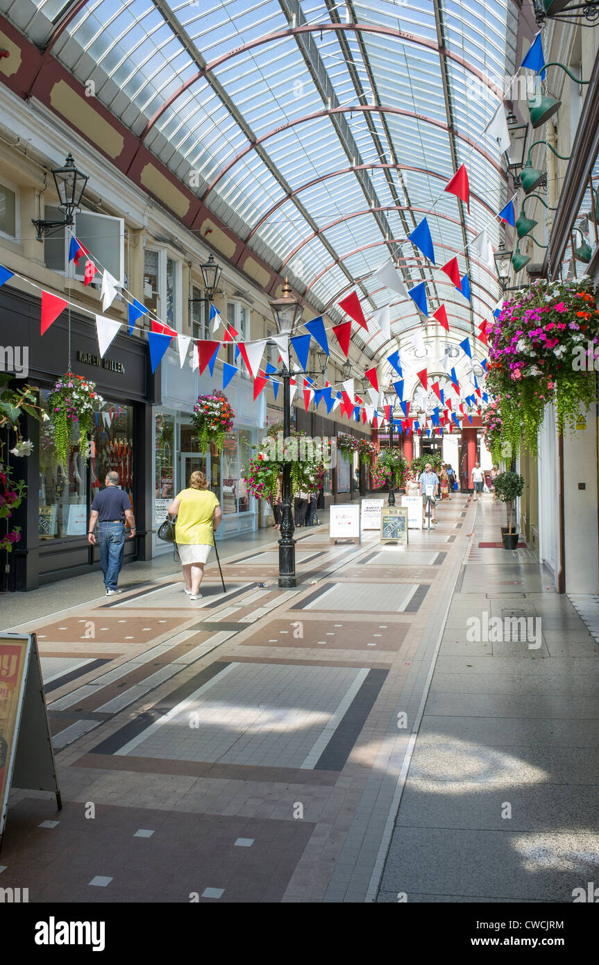 Victorian galleria di negozi con acquirenti e rosso bianco e blu bunting in Bournemouth Dorset Regno Unito Foto Stock