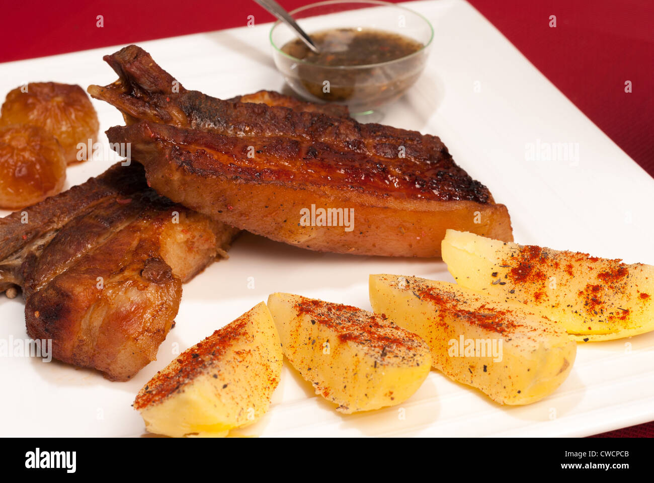 Caramellato alla griglia costolette di maiale servito con guarnire e argentino salsa chimichurri Foto Stock
