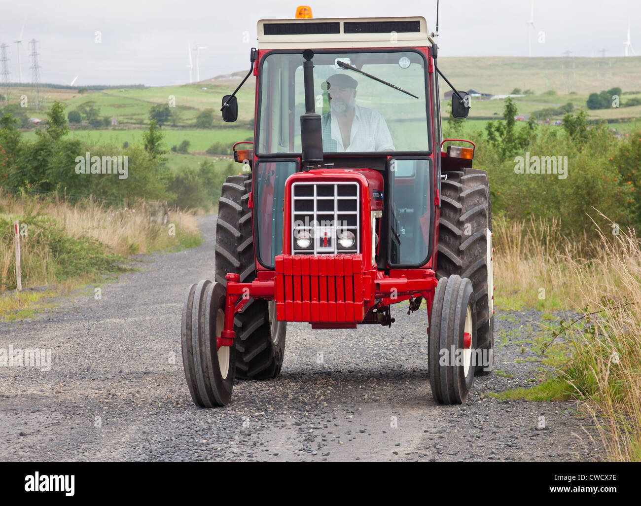 I ventilatori alla guida di una annata International Harvester 674 trattore durante un'Ayrshire Vintage del trattore e della macchina su strada Club run Foto Stock