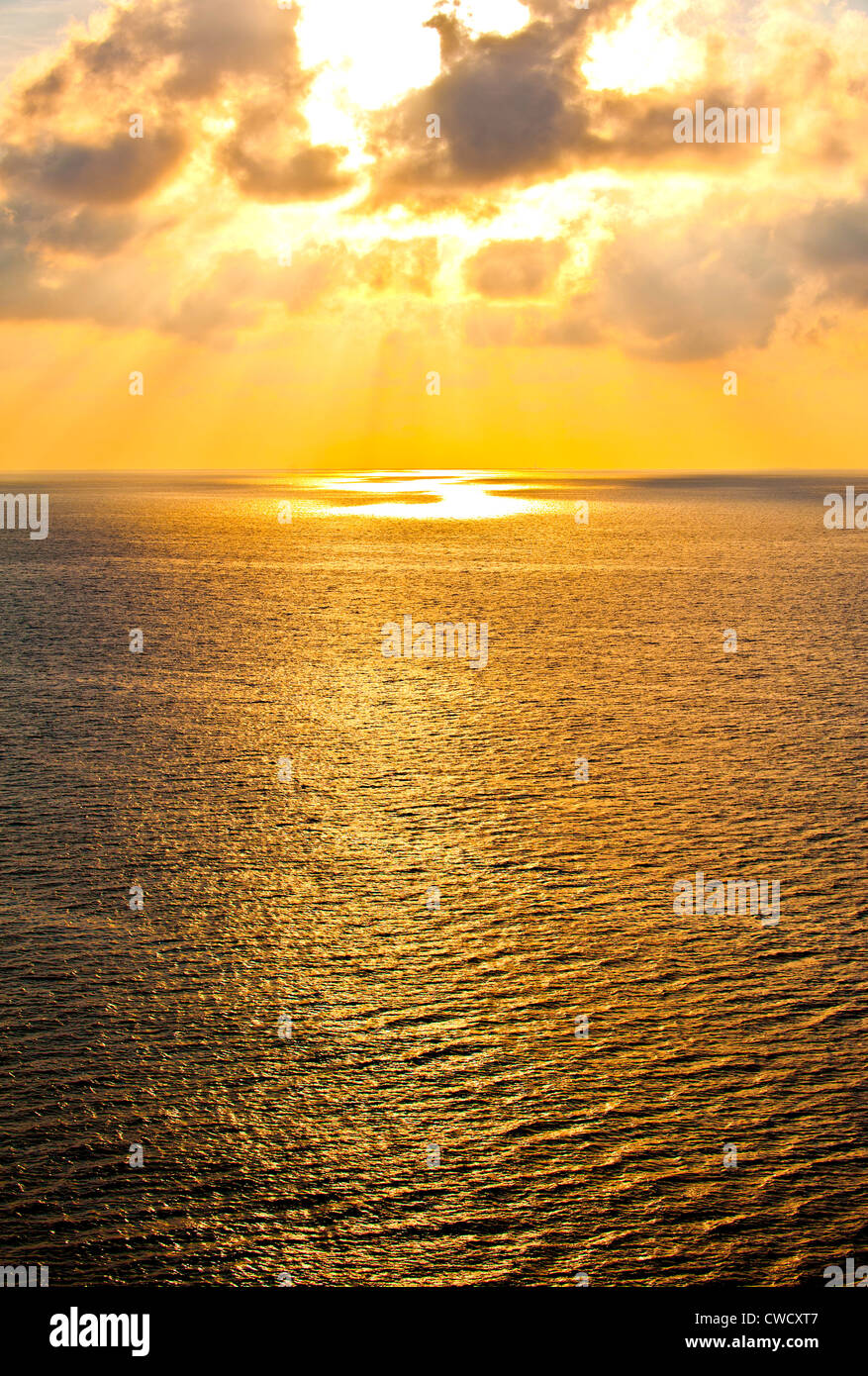 I raggi di luce dorata risplendere anche se le nuvole sul mare oltre il aperto oceano Atlantico al tramonto warming quelli a bordo della nave da crociera Foto Stock