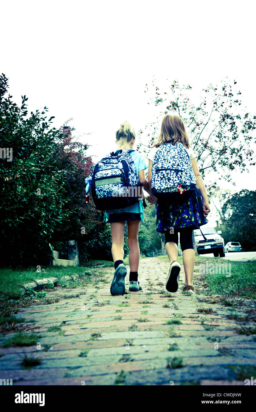 Due amici a casa a piedi da scuola Foto Stock