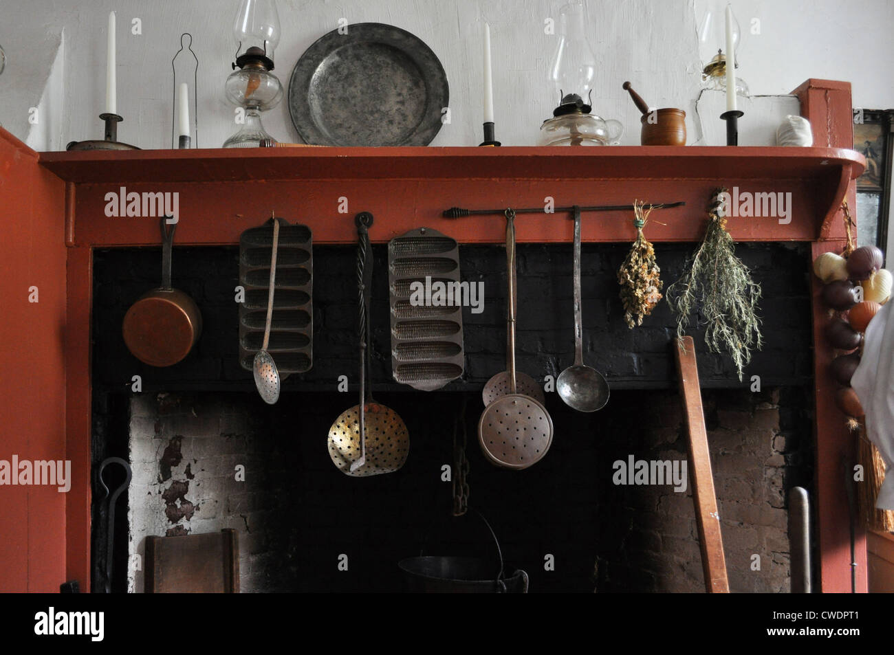 Antichi attrezzi da cucina appendere sul manto di una casa coloniale Foto Stock