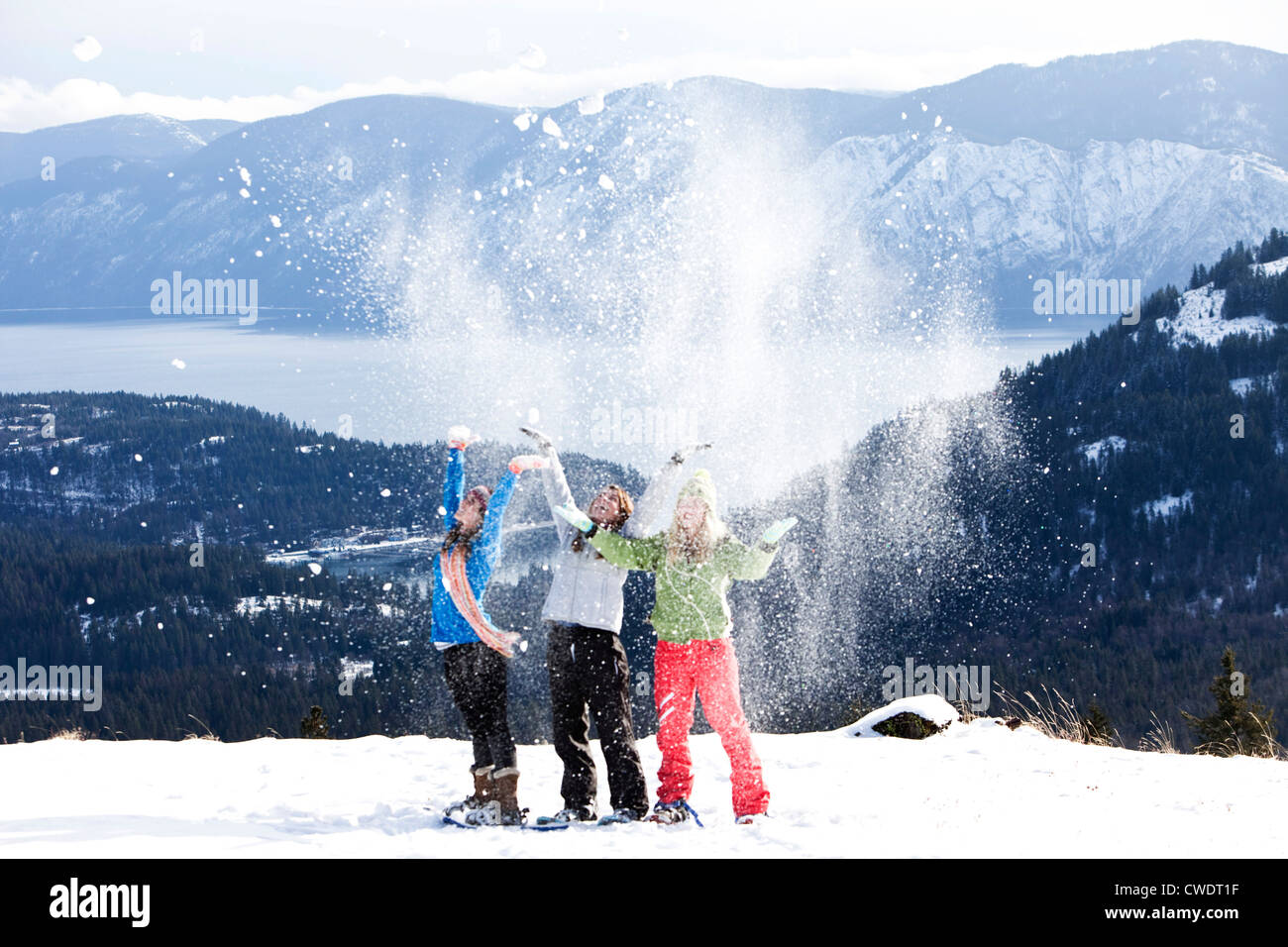 Tre femmine a giocare nella neve e nel lanciare in aria. Foto Stock