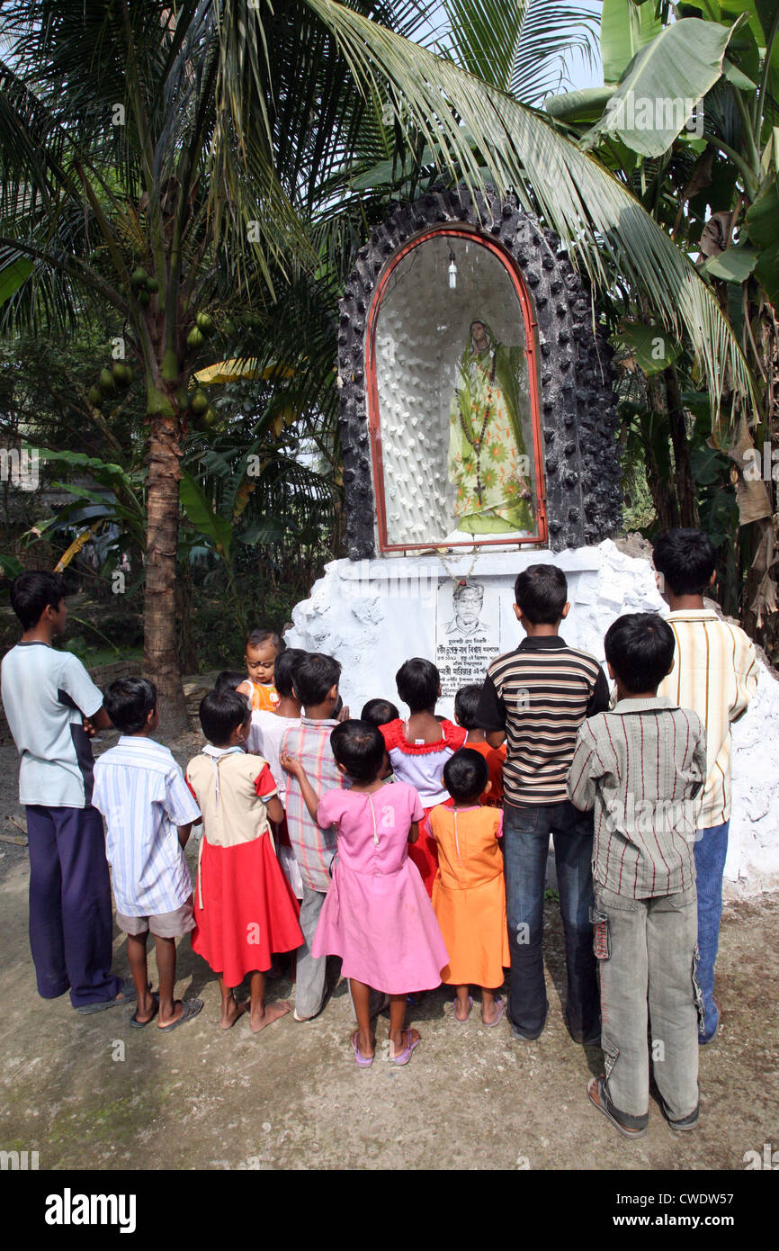 Un gruppo di giovani cattolici bengalesi pregano davanti alla statua della Vergine Maria a Basanti, Bengala Occidentale, India Foto Stock