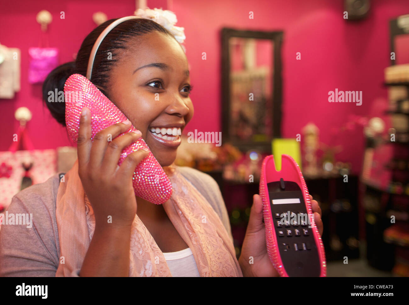 Una giovane donna che guarda su una novità telefono, Pietermaritzburg, KwaZulu-Natal, Sud Africa Foto Stock