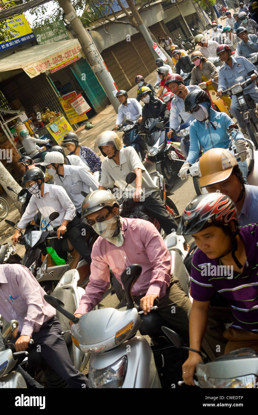 Vista orizzontale del caotico traffico delle ore di punta del traffico con centinaia di ciclomotori e i loro passeggeri pillion home guida. Foto Stock