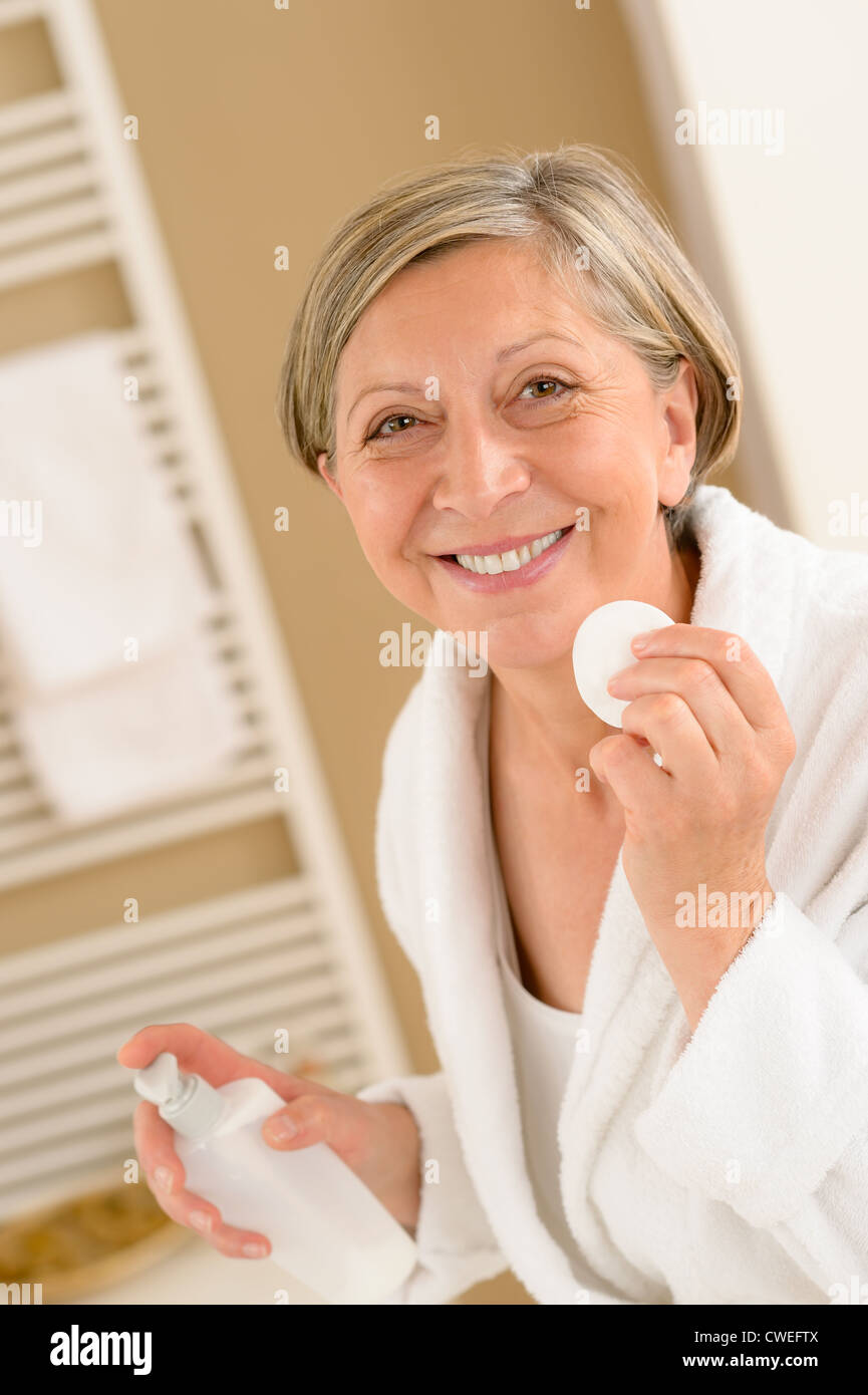 Senior donna viso pulito con tampone di cotone guardando la fotocamera Foto Stock