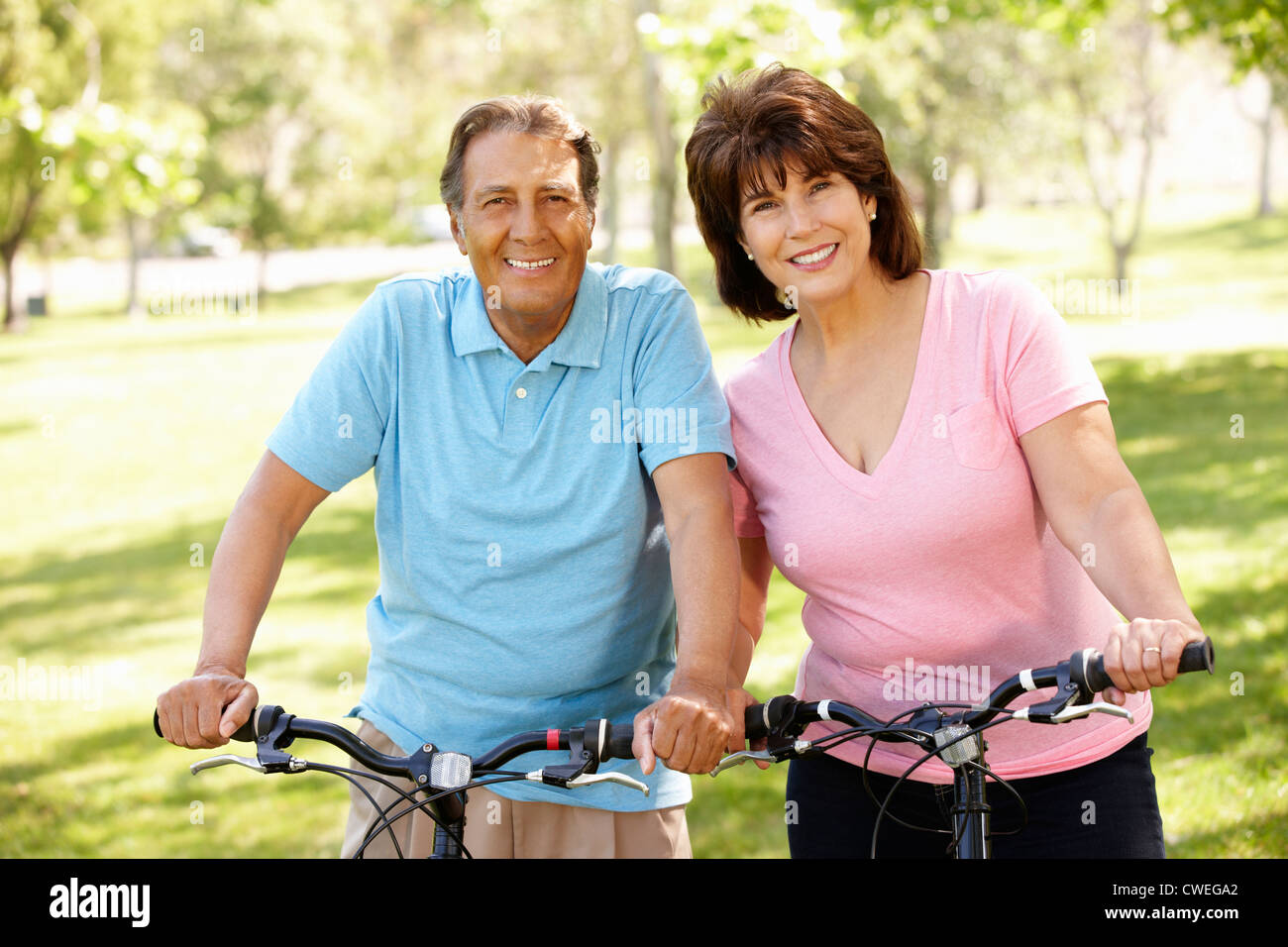 Senior coppia ispanica in bici Foto Stock