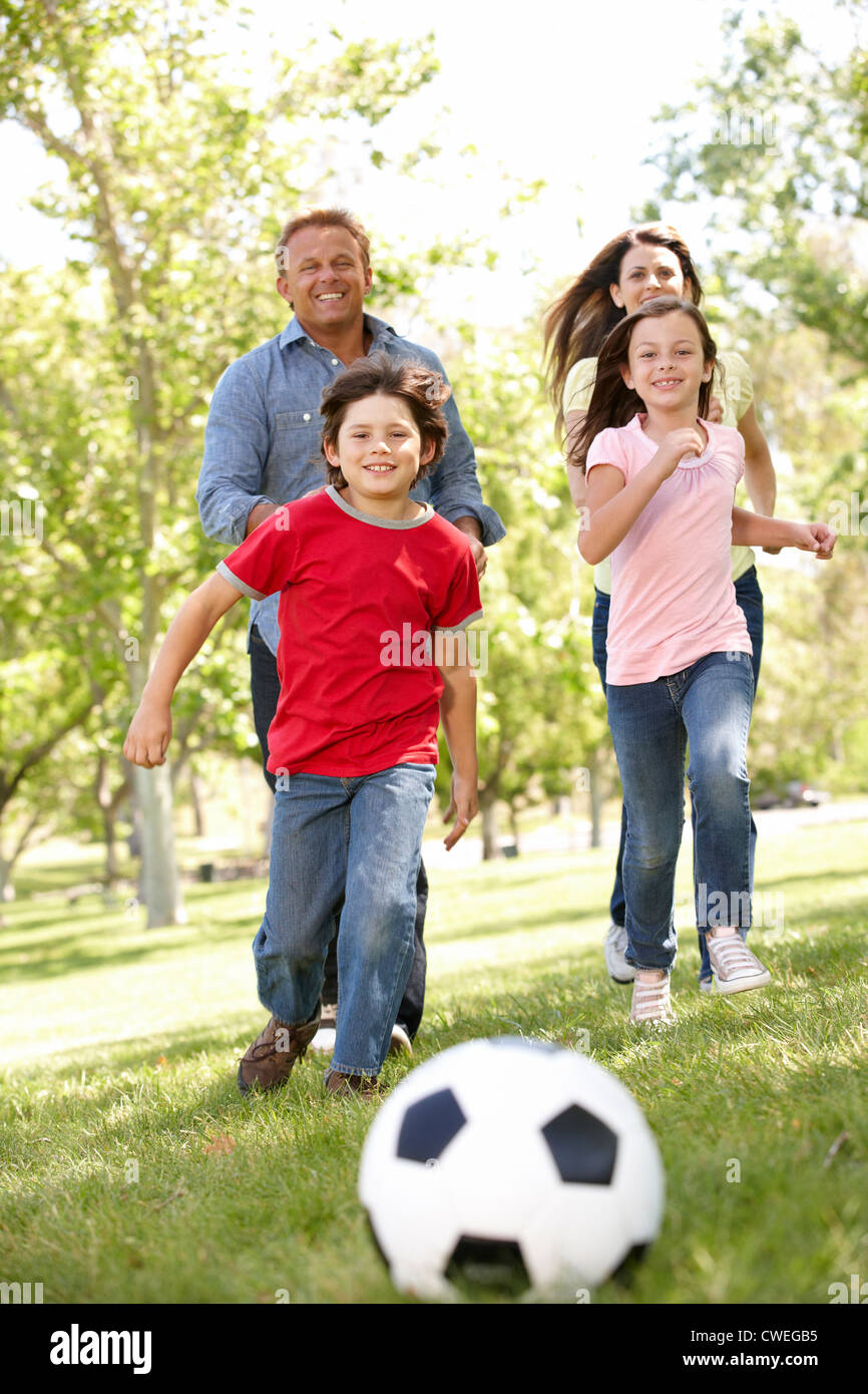 Famiglia giocando a calcio in posizione di parcheggio Foto Stock