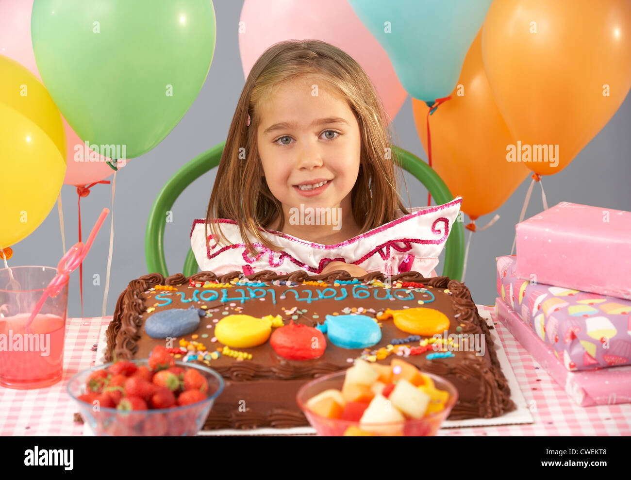 Ragazza giovane con la torta di compleanno e regali a parte Foto Stock