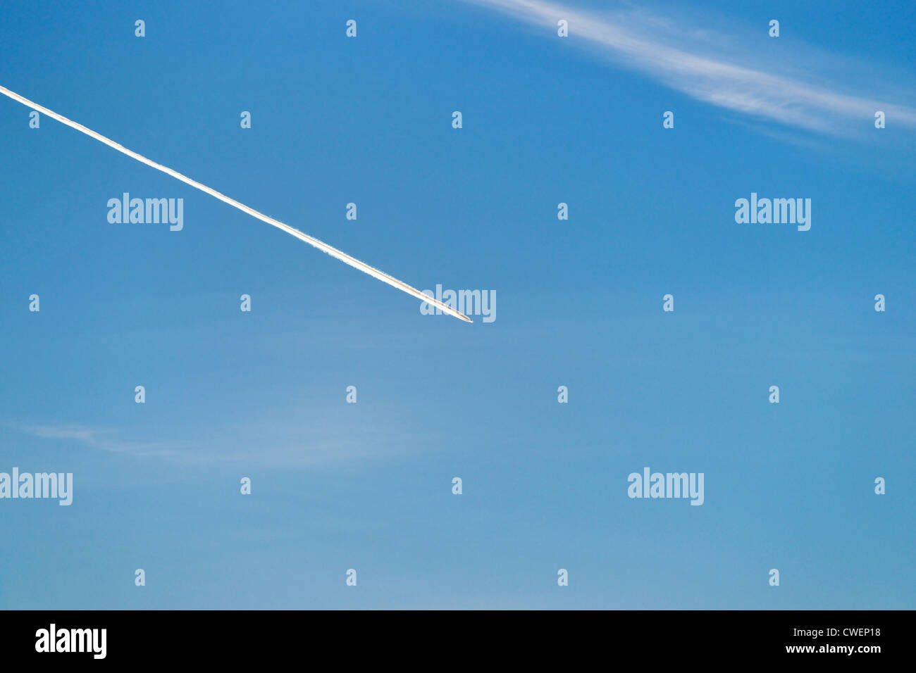 Sentiero di vapore di un aereo jet attraversando un cielo azzurro. Foto Stock