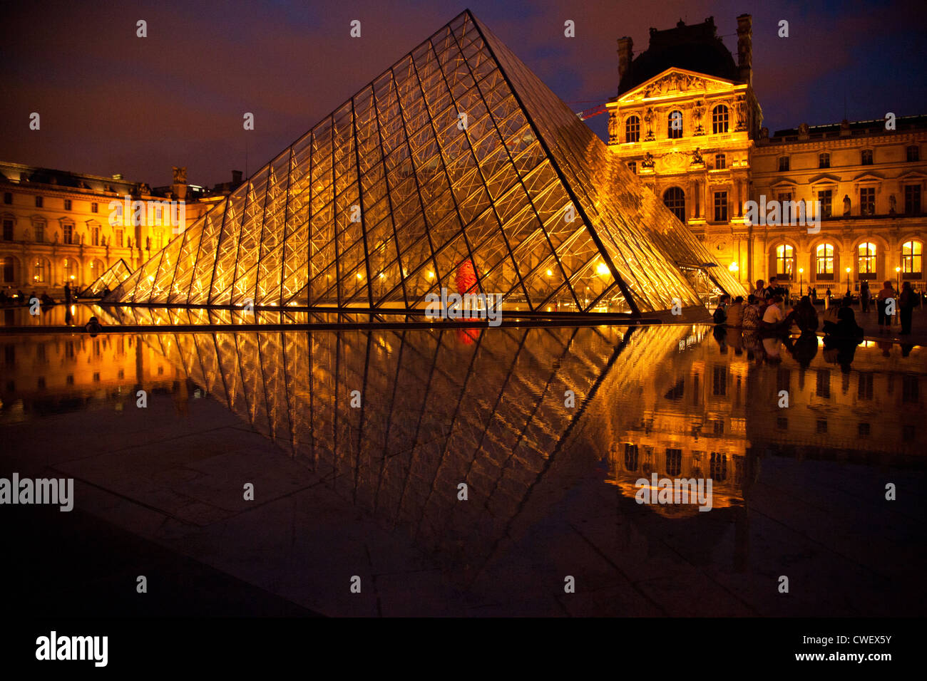 La piramide di vetro nella cour Napoleone con il Louvre in background in una serata estiva in Parigi Foto Stock