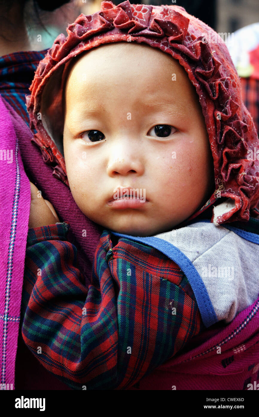 Il nepalese Newar piccolo bambino in un cappuccio rosso. Close-up. Bhaktapur, Valle di Kathmandu, Nepal Foto Stock