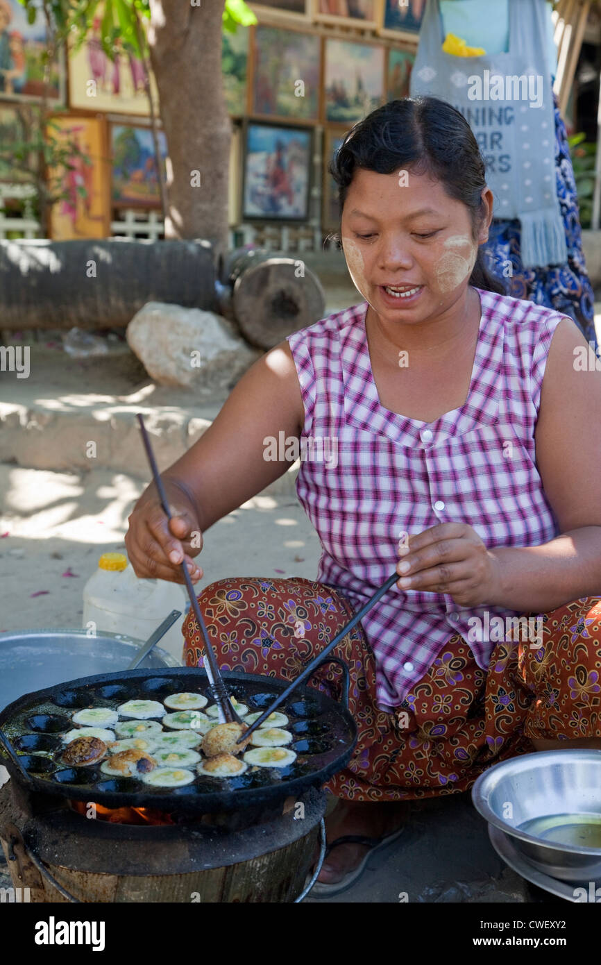 Myanmar Birmania. Mingun. Street-food Vendor pastosa di frittura snack. Indossa thanaka incollare sul suo volto, un cosmetico sunscreen. Foto Stock