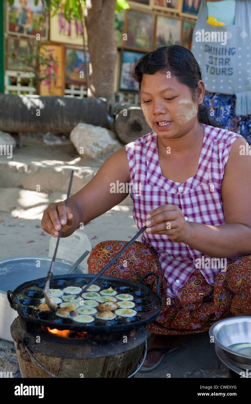 Myanmar Birmania. Mingun. Street-food Vendor pastosa di frittura snack. Indossa thanaka incollare sul suo volto, un cosmetico sunscreen. Foto Stock