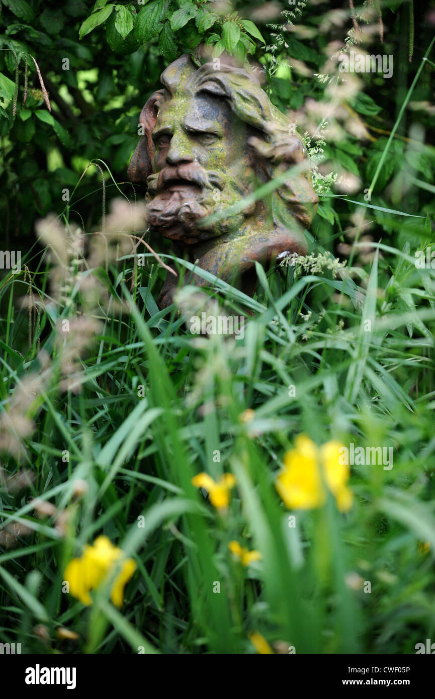 Una statua nascosta da sottobosco in un giardino England Regno Unito Foto Stock