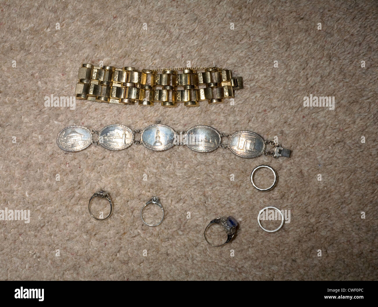 Una collezione di gioielli di una donna, tra cui anelli e un bracciale che mostra luoghi famosi Foto Stock