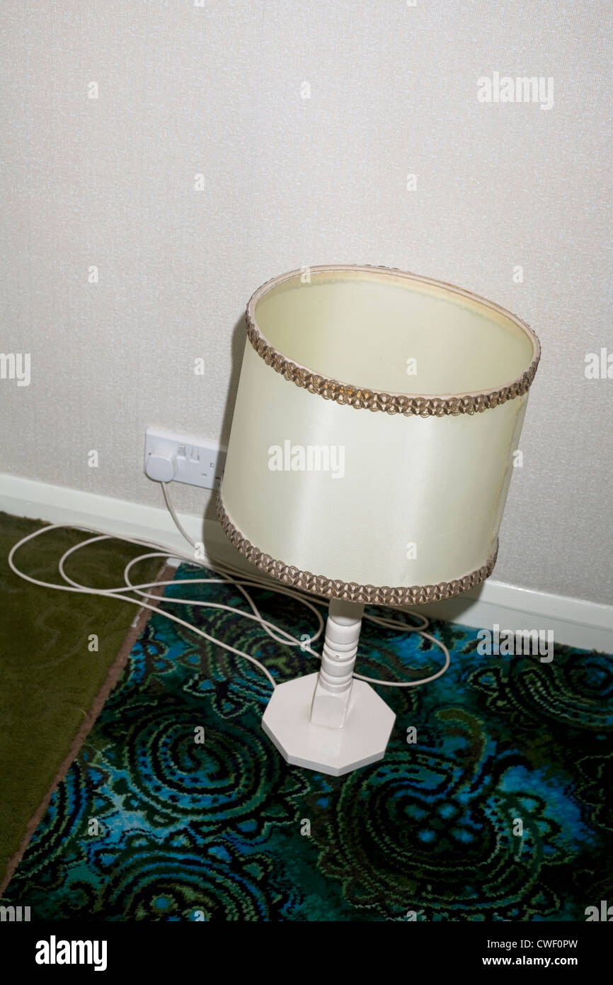 Una lampada da tavolo con paralume seduto su un pavimento di moquette Foto Stock