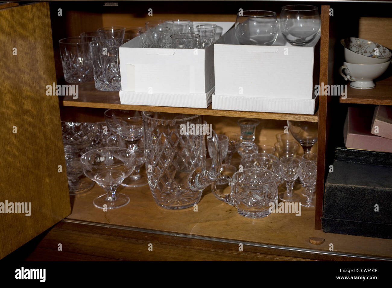 Una collezione di tagliare vetro cristallo vetreria all'interno di una credenza in legno Foto Stock