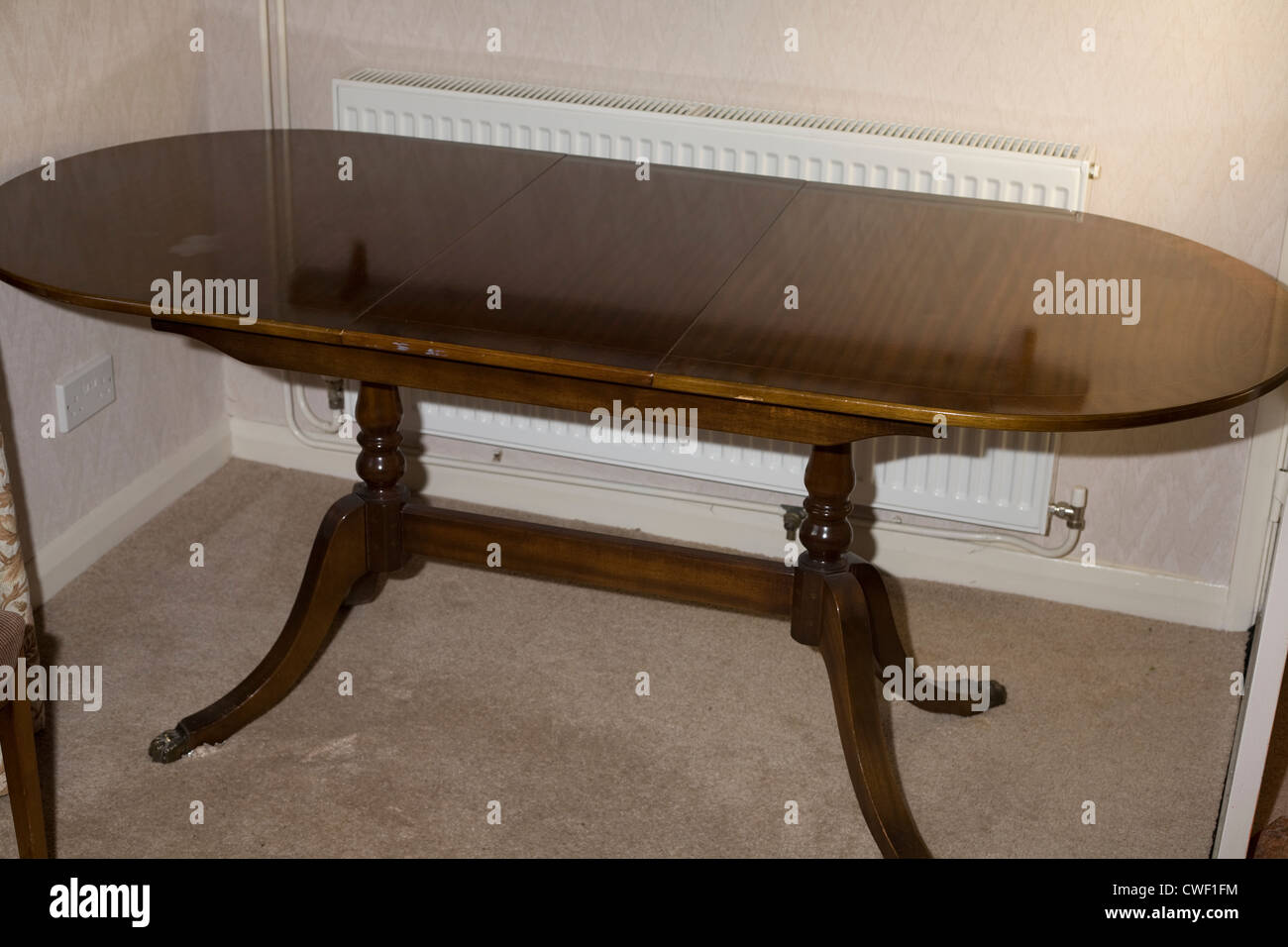 Tavolo da pranzo in legno nella sala da pranzo con radiatore dietro Foto Stock