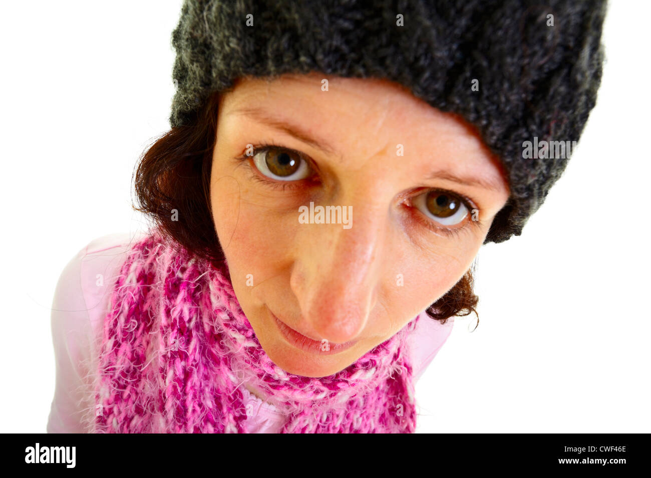 I giovani i capelli castani donna con un tappo di lana rende divertente l'espressione del viso, isolato su sfondo bianco, studio shot. Adobe RGB Foto Stock