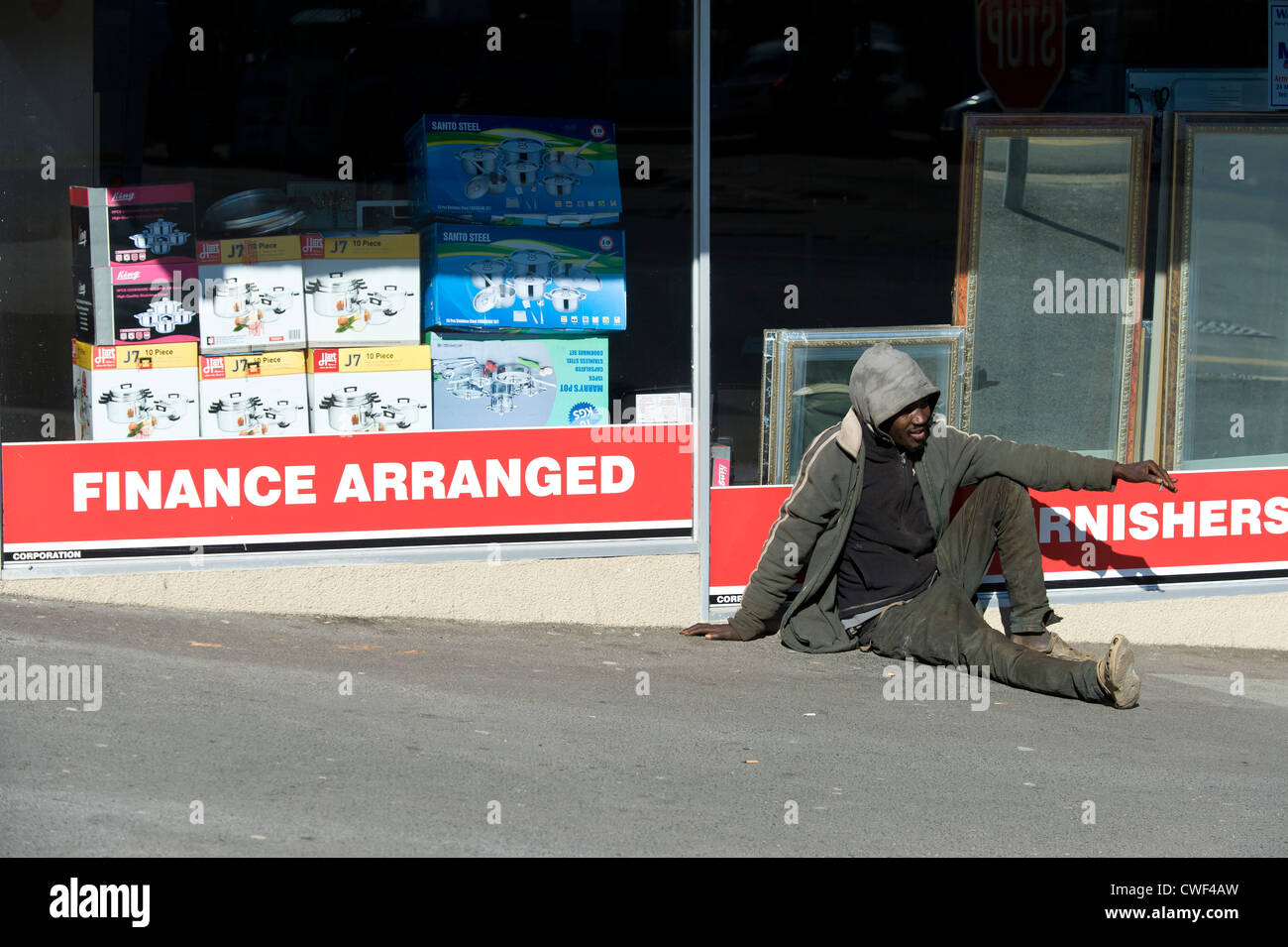 Sacchi in uomo seduto su una strada di Città del Capo in Sud Africa Foto Stock