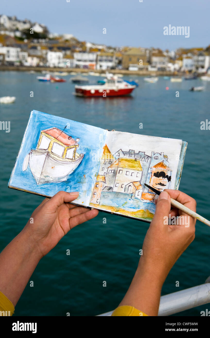 Un artista dipinge barche da pesca nel porto di St ives cornwall Foto Stock