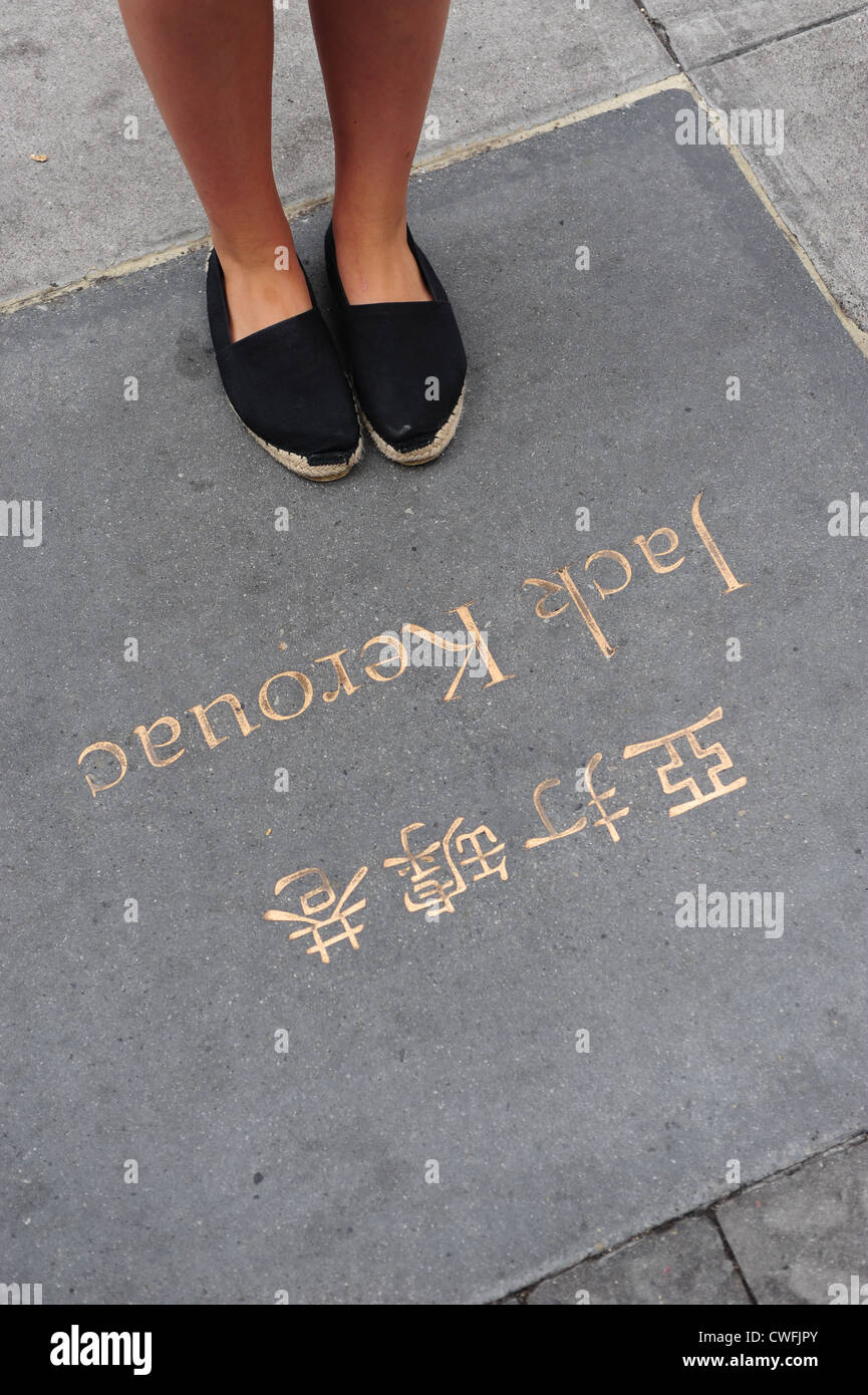 Stati Uniti d'America California CA San Francisco - donna in piedi su un omaggio al poeta scrittore Jack Kerouac accanto alle luci della città libri Foto Stock