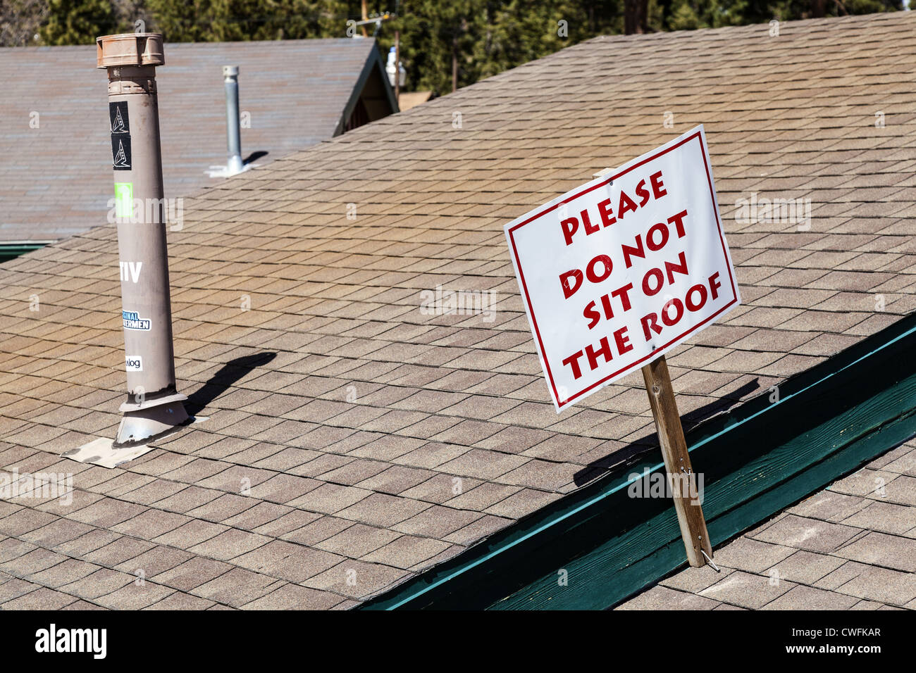 'Non sedersi sul tetto' segno sulla costruzione sul fondo delle piste da sci a Big Bear Mountain in Calfornia, STATI UNITI D'AMERICA Foto Stock