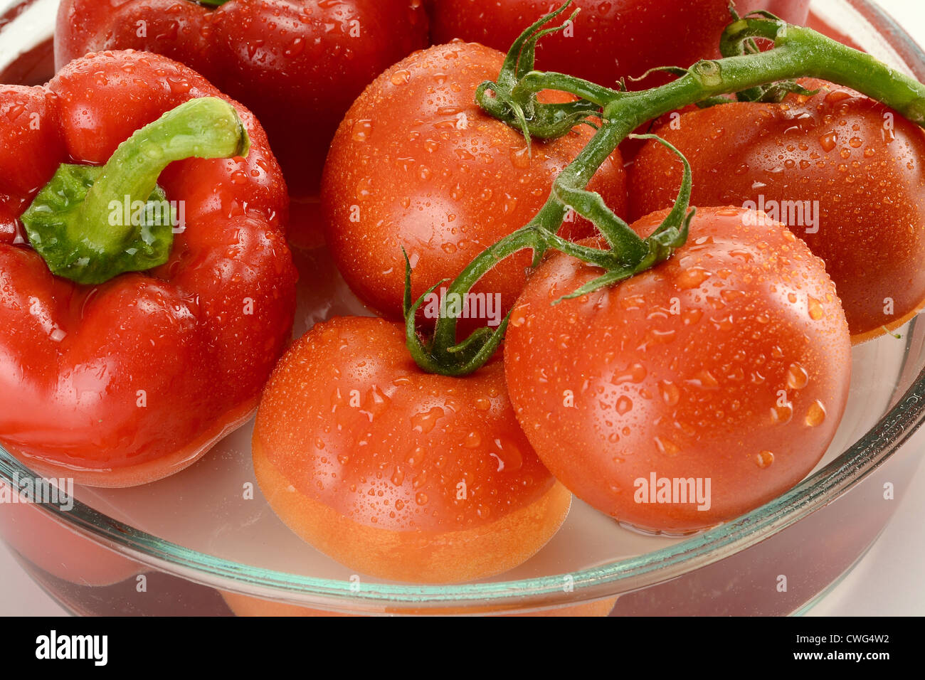 Appena Lavate i pomodori e pepe rosso in vetro piatto di cucina Foto Stock