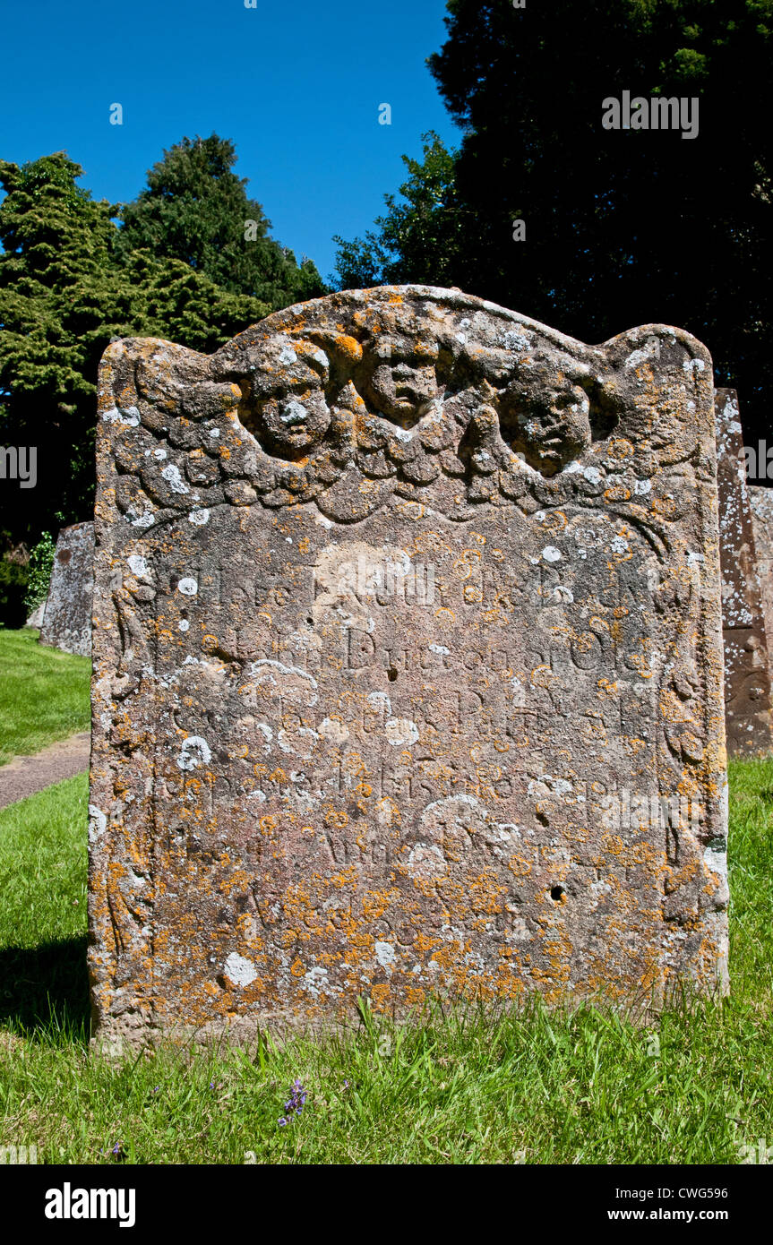 Antica tomba di pietra o di grave con il lichen e carving di tre testine di angeli in St James Church yard Chipping Campden Cotswolds Foto Stock