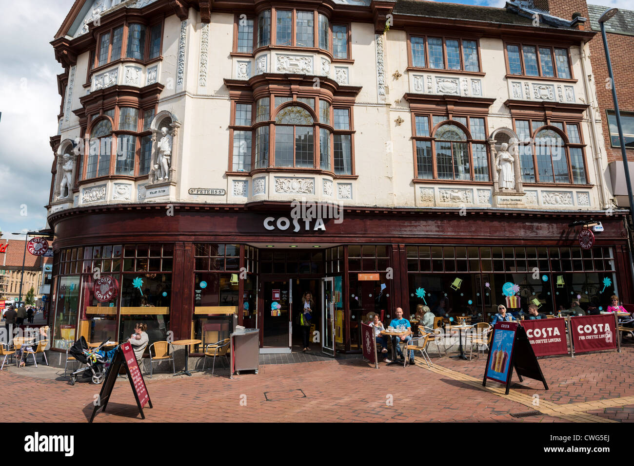 Arti e Mestieri edificio in stile stivali in precedenza il chimico ora Costa Coffee in Derby. L'edificio ospita 4 statue in gesso. Foto Stock