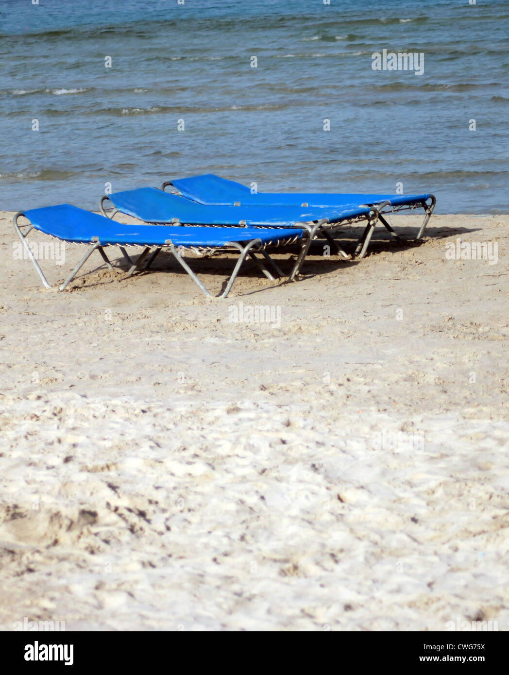 Sedie a sdraio o lettini sulla spiaggia di sabbia in estate. Foto Stock