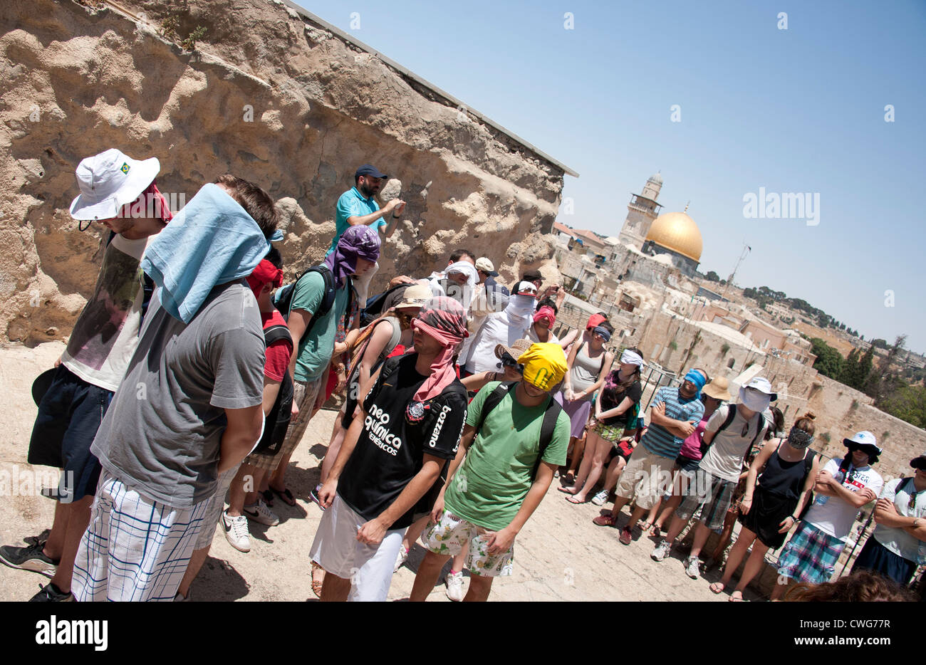 Un gruppo di visitatori sono guidati con gli occhi bendati da un punto di vista che si affaccia sul Muro Occidentale di Gerusalemme, Israele Foto Stock