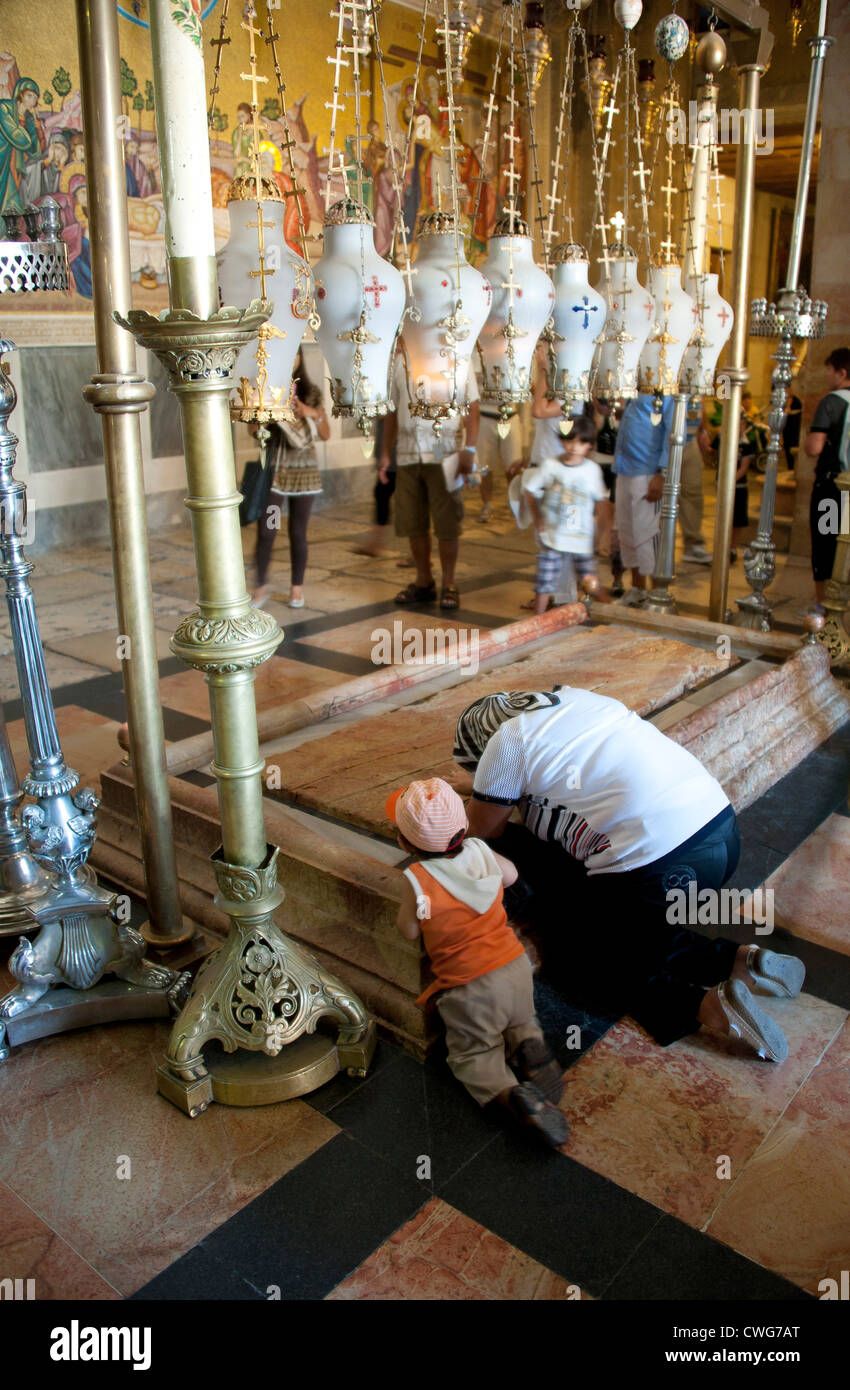 Visitatori pregare e baciare la pietra dell'unzione, presso la chiesa del Santo Sepolcro a Gerusalemme, Israele. Foto Stock