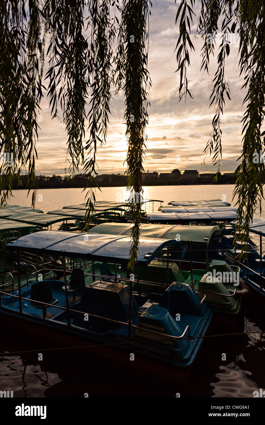 Barche a remi allineati lungo le rive durante il tramonto al Parco Beihai a Pechino in Cina Foto Stock