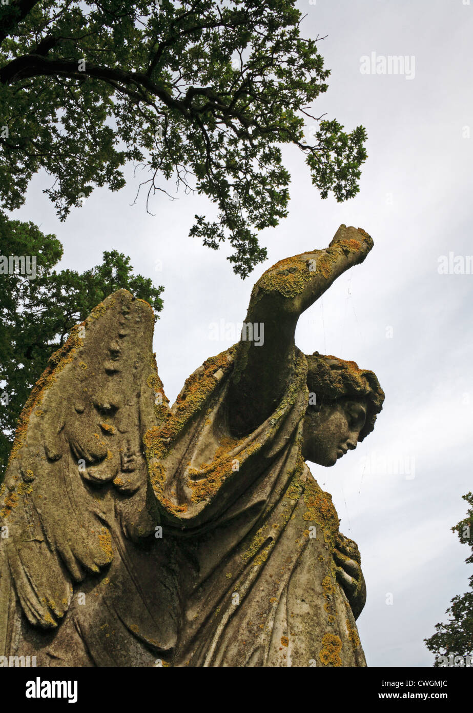 Un angolo di visualizzazione di un angelo statua con il braccio sollevato nel sagrato a Besthorpe, Norfolk, Inghilterra, Regno Unito. Foto Stock