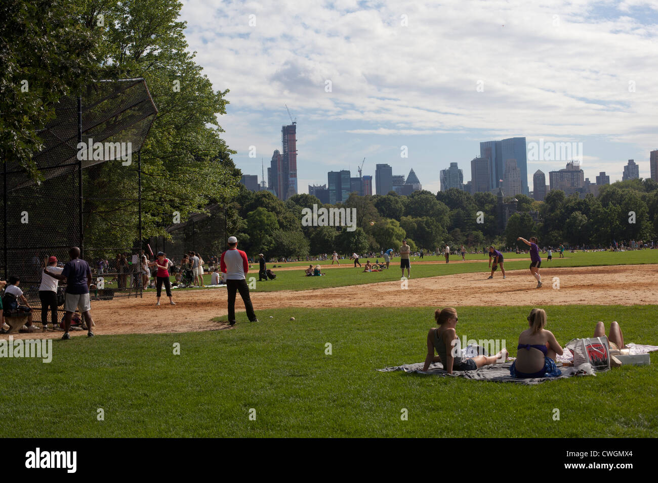 I Newyorkesi giocare a softball in estate sul grande prato di central park Foto Stock