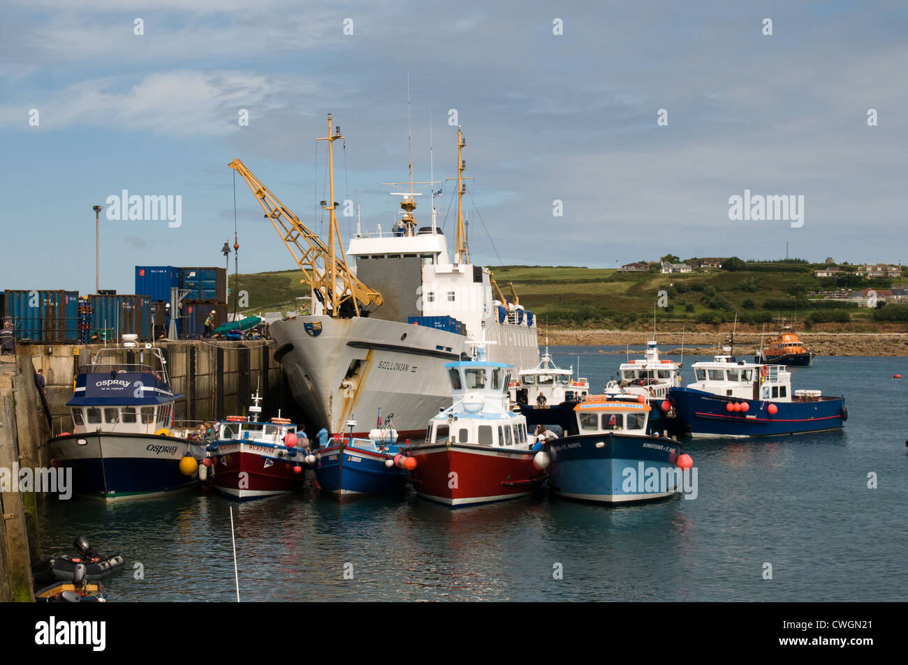 Il Scillonian III off carica cargo presso la banchina di Hugh porto cittadino, St Mary, Isola di Scilly. Off isola ferries attendere a fianco Foto Stock