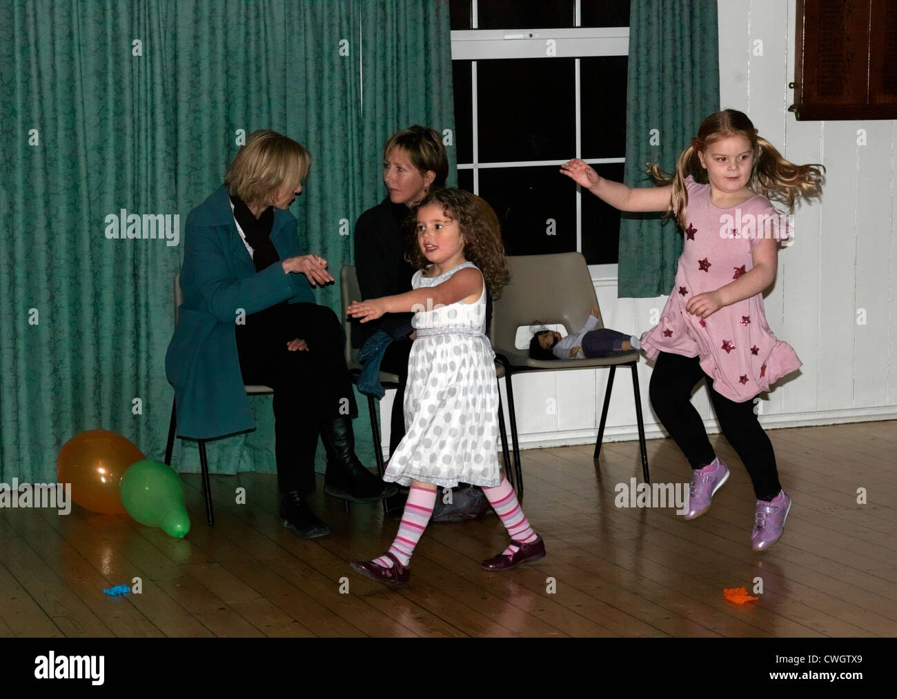 I bambini danza saltando passato i genitori ad una discoteca a un quinto compleanno Inghilterra Foto Stock