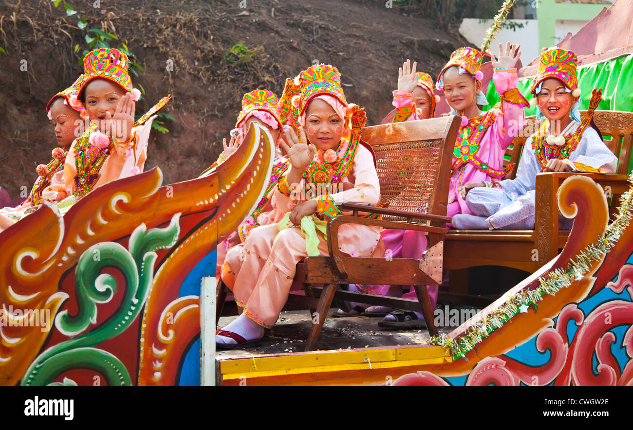 Le ragazze in costume sono parte di una processione di giovani uomini di entrare in un monastero buddista in KENGTUNG - Myanmar Foto Stock