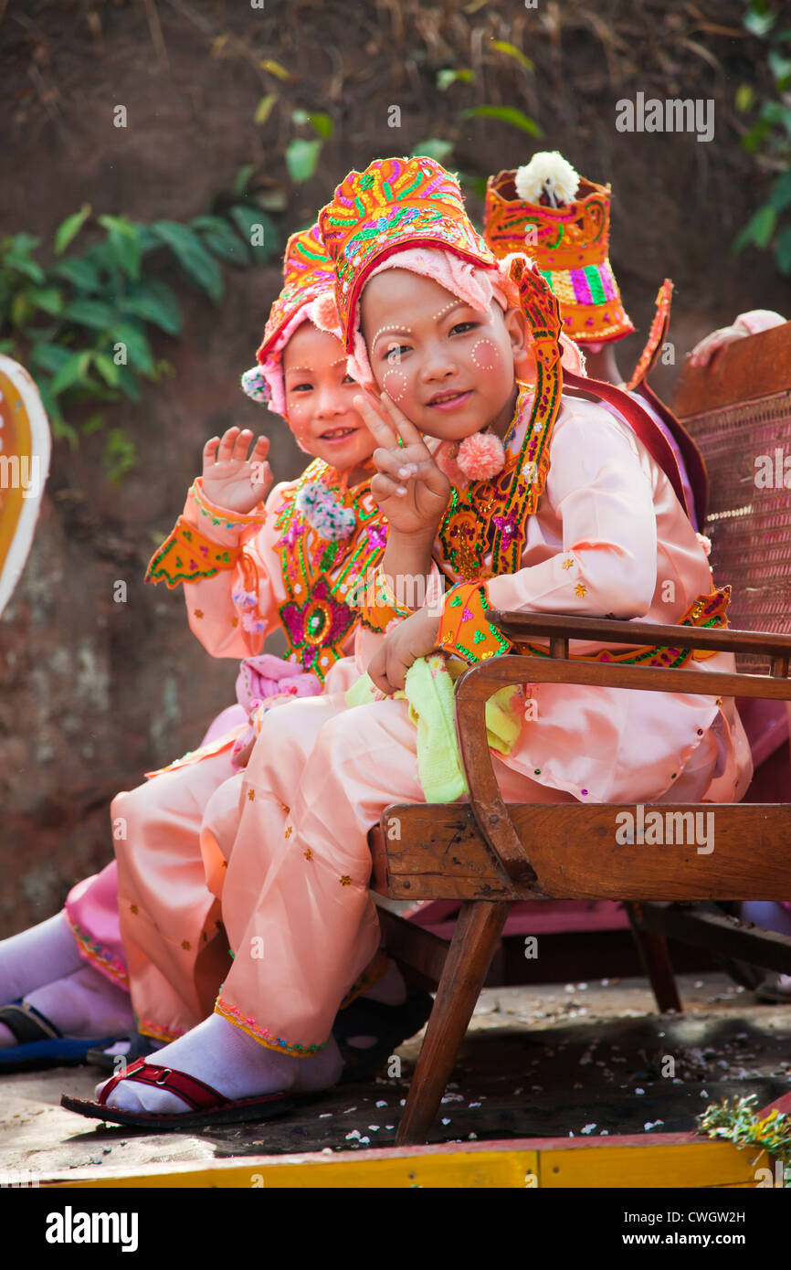 Le ragazze in costume sono parte di una processione di giovani uomini di entrare in un monastero buddista in KENGTUNG - Myanmar Foto Stock