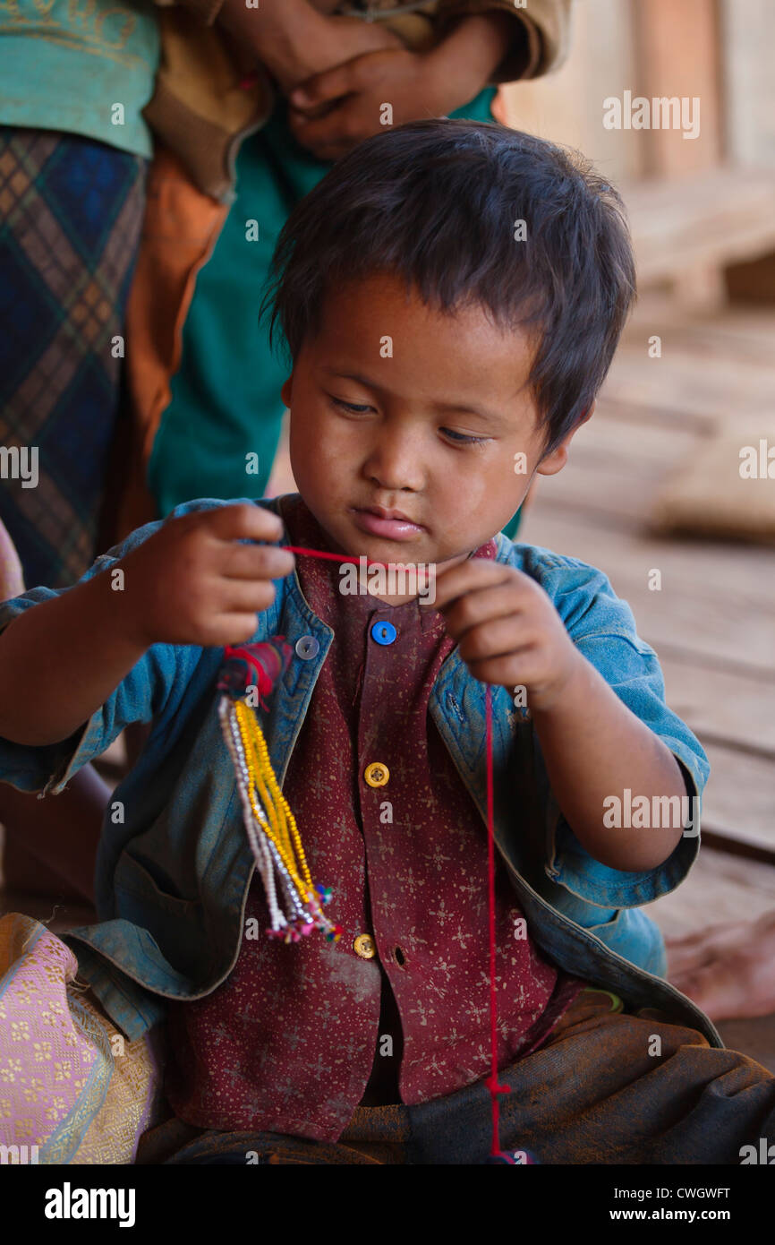 Un bambino da ANN tribù gioca con cordone a lavorare in un villaggio nei pressi di Kengtung o KYAINGTONG - Myanmar Foto Stock