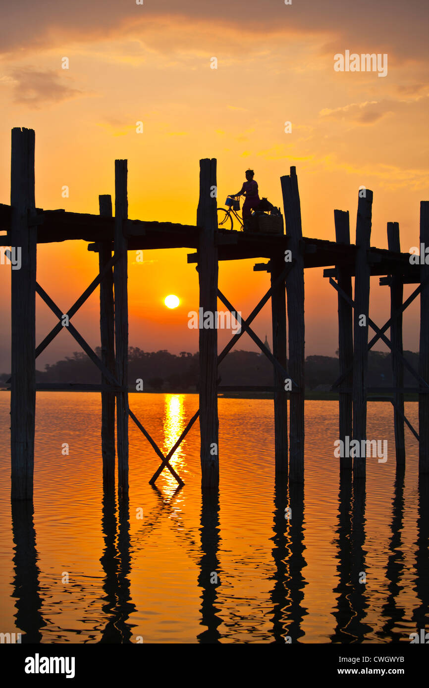Il birmano utilizzare il teak U BEINS ponte per commutare tra il Lago Taungthaman presso sunrise - AMARAPURA, MYANMAR Foto Stock