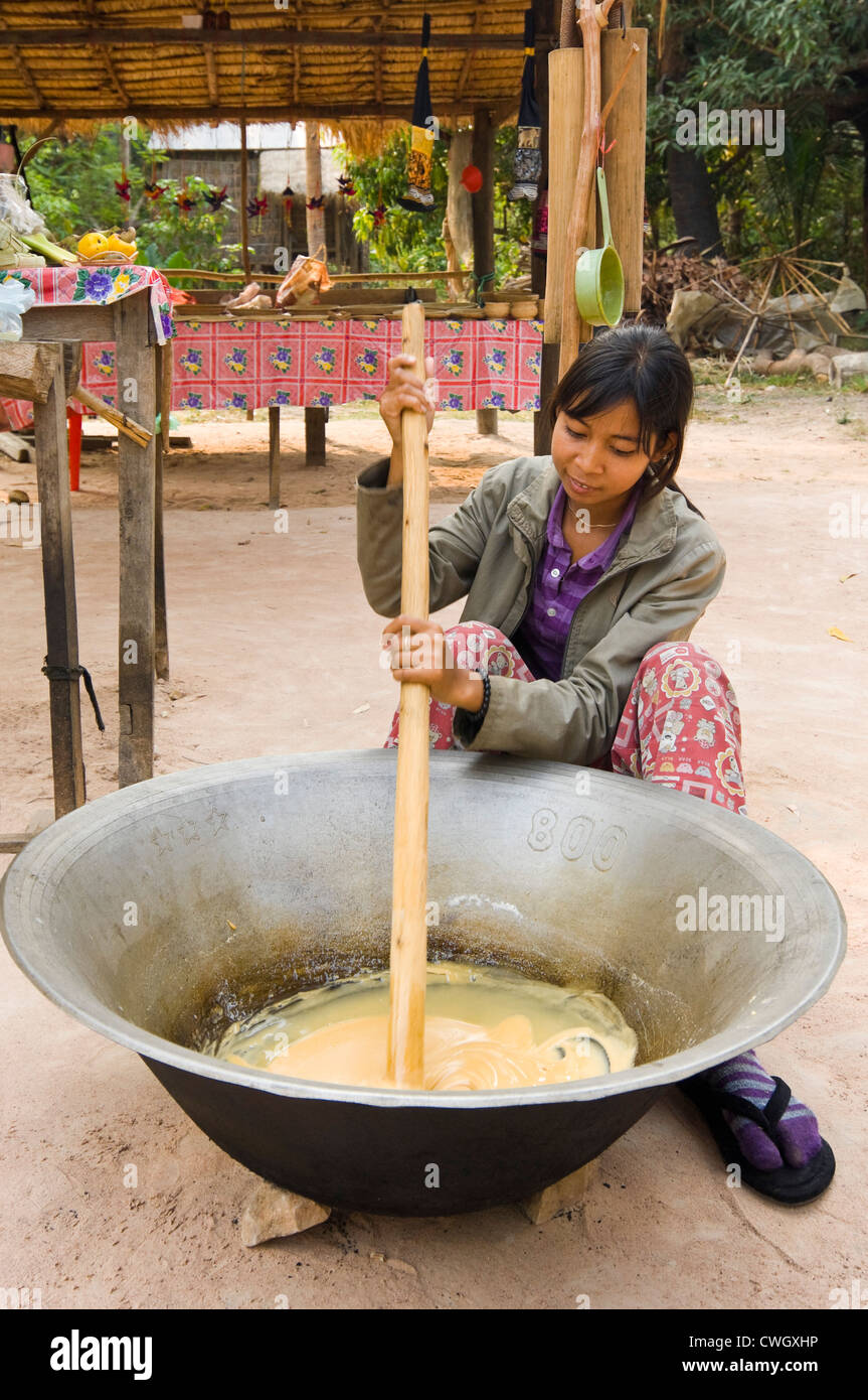 Ritratto verticale di un cambogiano donna fare palm tradizionali dolci di zucchero anche ampiamente utilizzato in Cambogia e cucina asiatica. Foto Stock